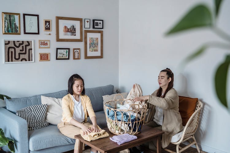 Mother And Daughter Folding Clothes Together