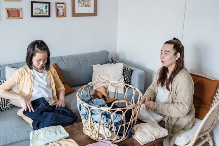 Woman And Child Folding Their Clothes