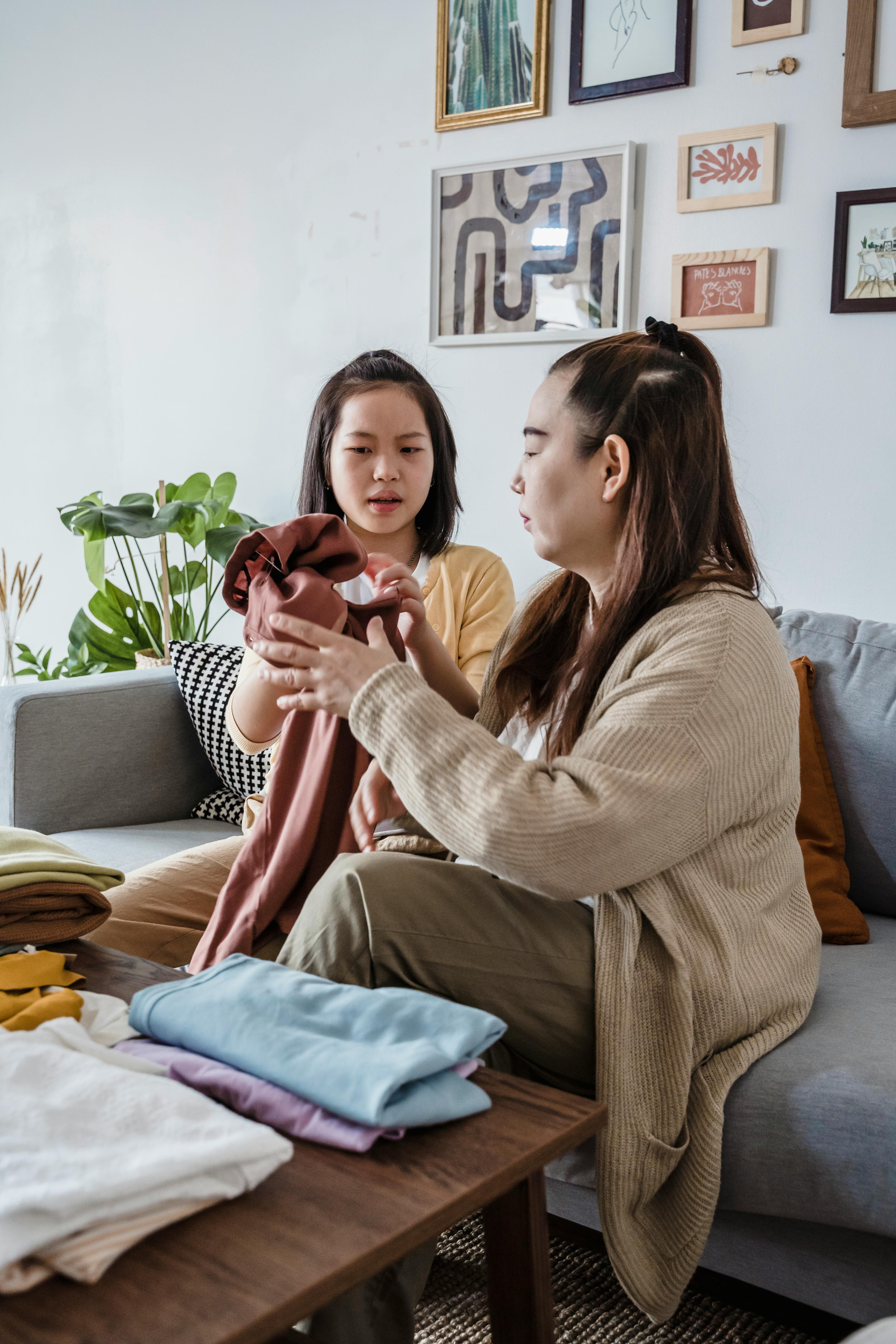 mother and daughter holding clothes together