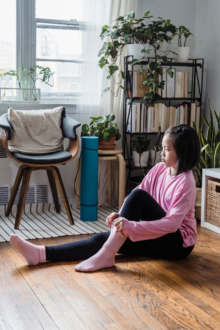 Child Putting On A Pink Socks