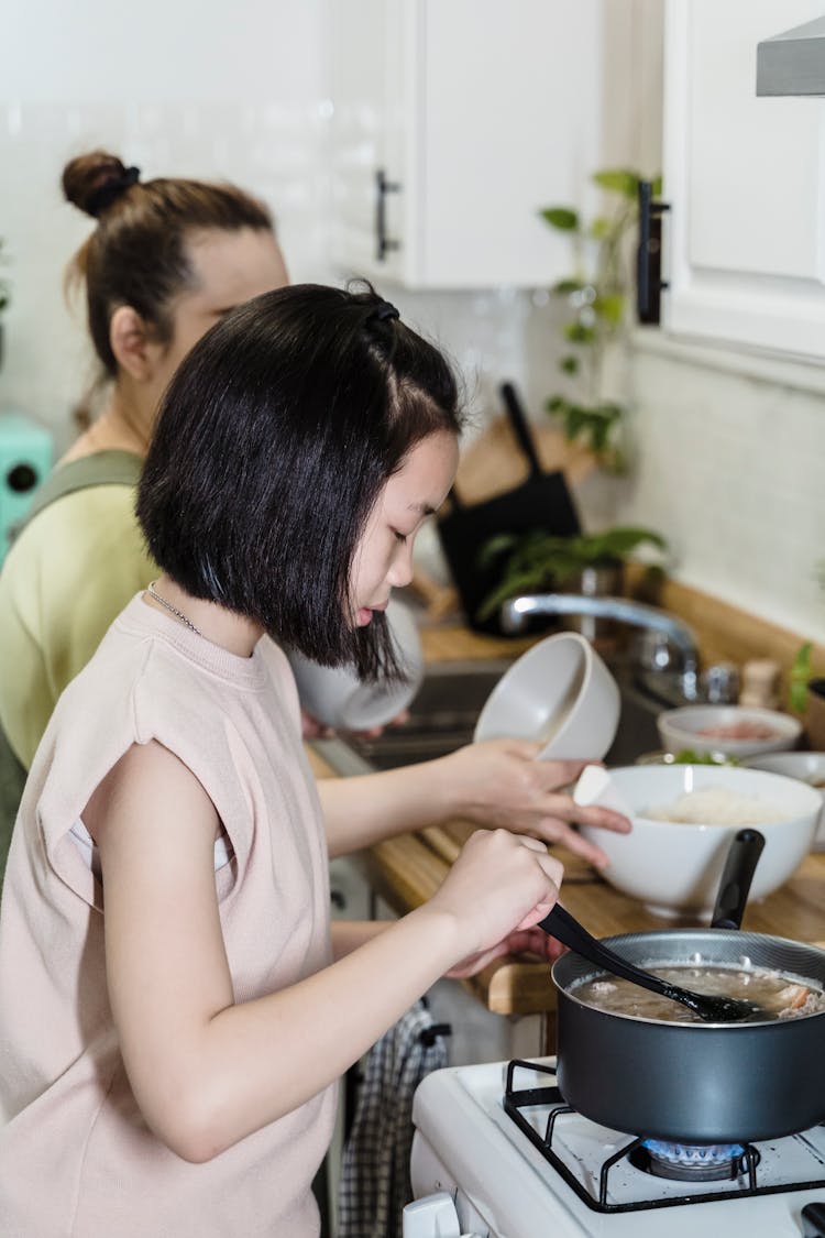 Mother And Daughter Cooking Together