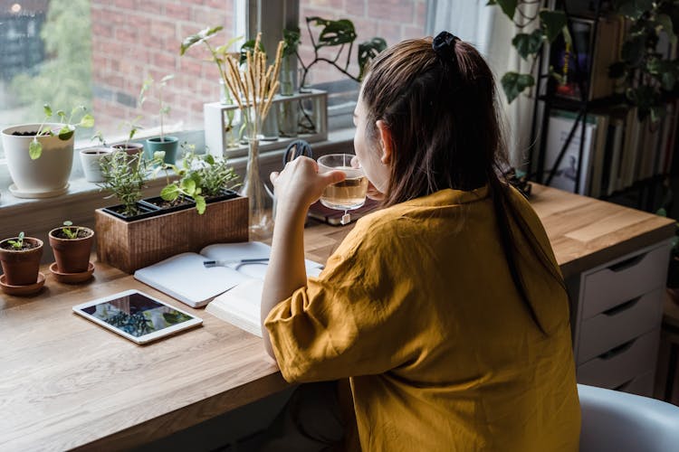 A Woman Drinking Tea At Her Home Office