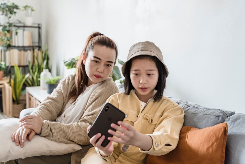 スマートフォンで口コミを確認する親子のイメージ