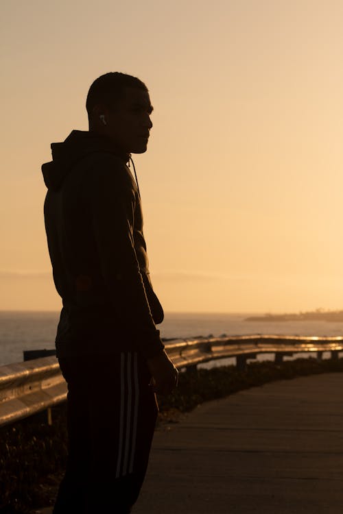 Silhouette of a Man Standing on the Road