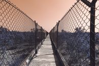 Black Metal Fence on Gray Concrete Road during Sunset