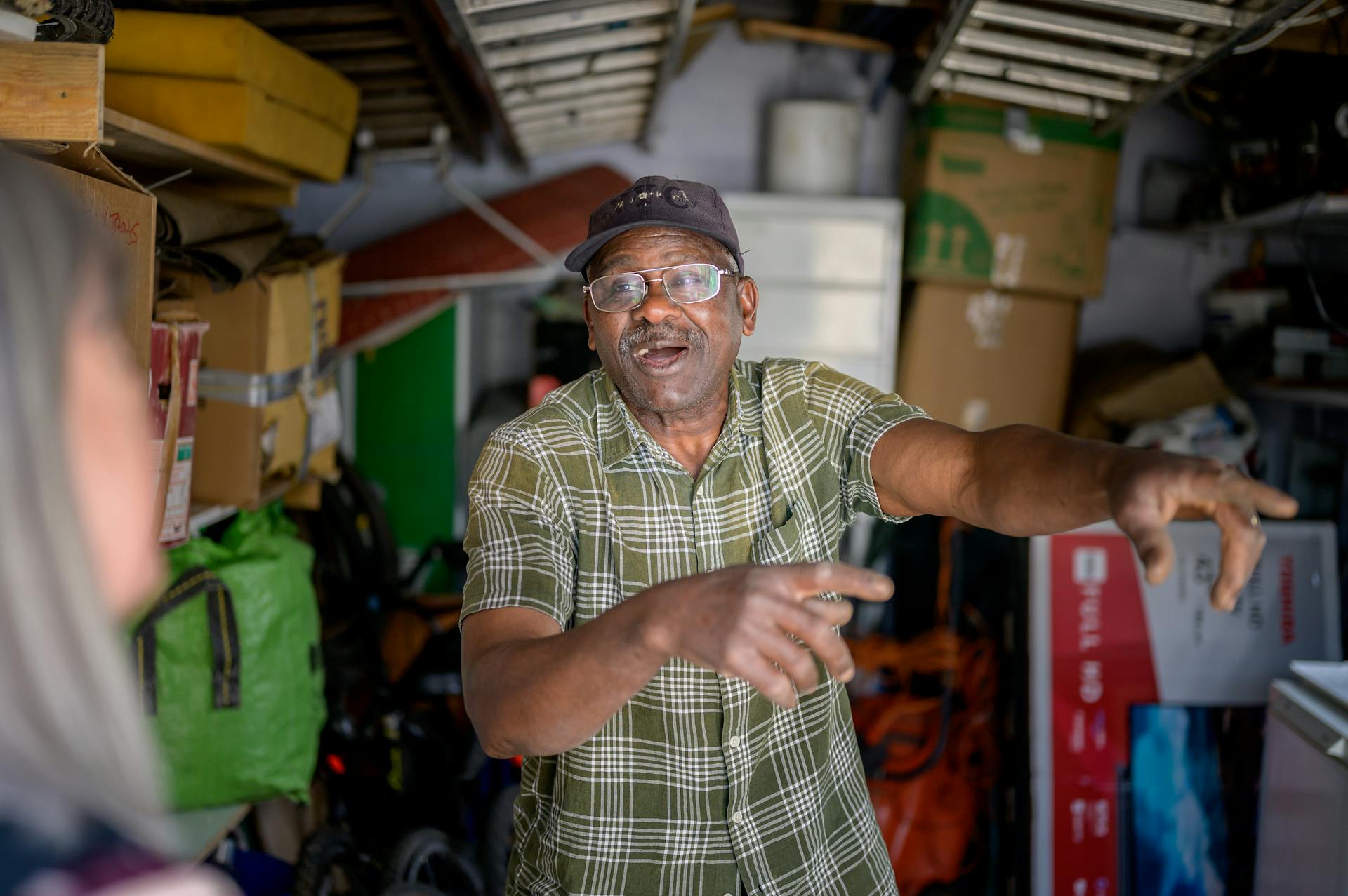 Man in a plaid shirt organizing boxes in a storage room.