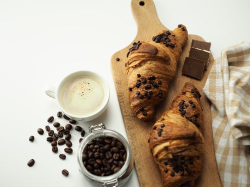 Free Indulge in a delightful breakfast featuring fresh croissants, coffee, and chocolate. Stock Photo