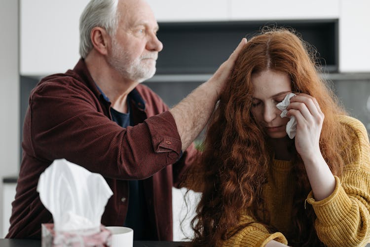 An Elderly Man Consoling A Woman