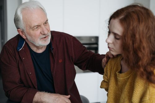 Free An elderly man consoles a young woman indoors, expressing empathy and understanding. Stock Photo