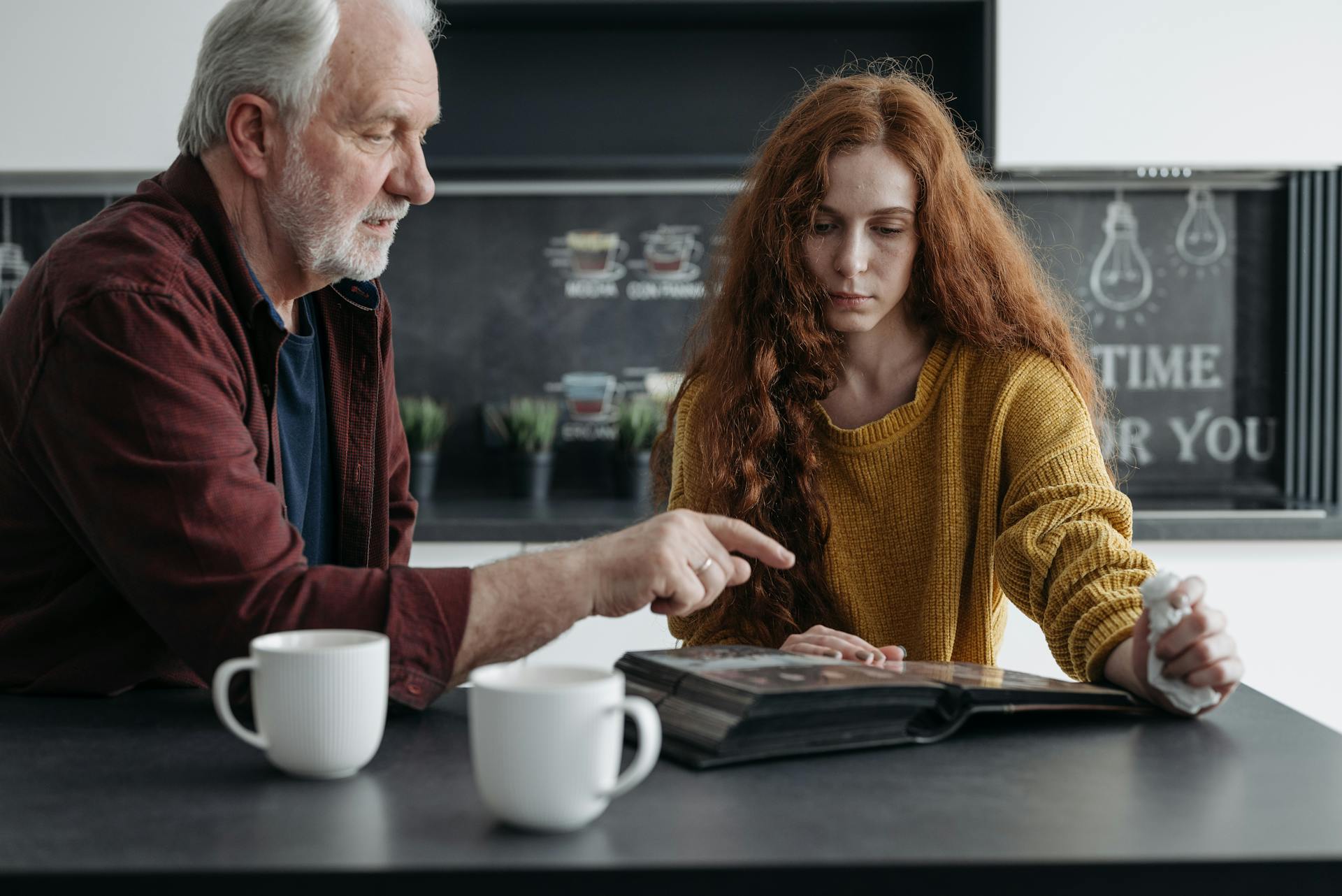 A Father and Daughter Looking at a Photo Album