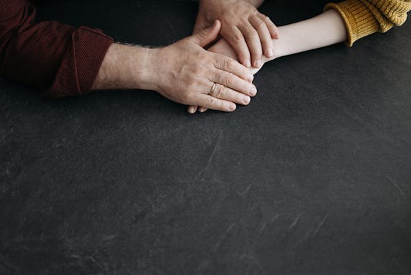 Close-up of hands showing caring touch, symbolising support and connection