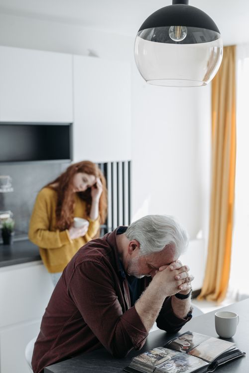 Free An elderly man reflects on memories with a photo album at home. Emotional and thoughtful scene. Stock Photo