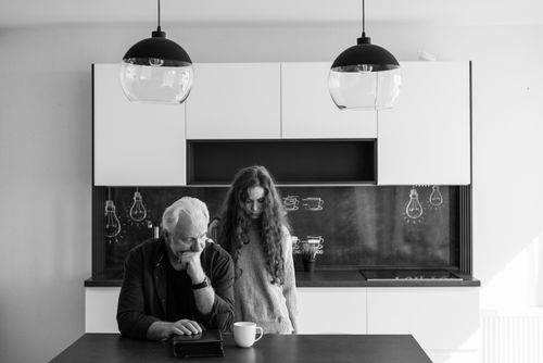 Free A father and daughter sharing a pensive moment in a modern kitchen setting. Stock Photo