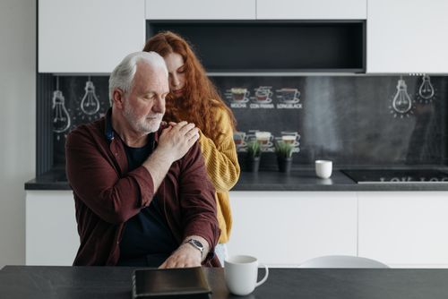 Free Emotional scene of a father and daughter sharing a tender, supportive moment in a modern kitchen. Stock Photo