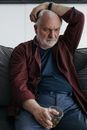 Man in Brown Leather Jacket Sitting on Black Leather Couch