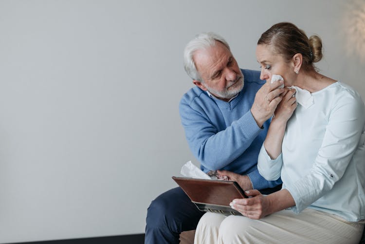 An Elderly Man Wiping His Wife Tears 