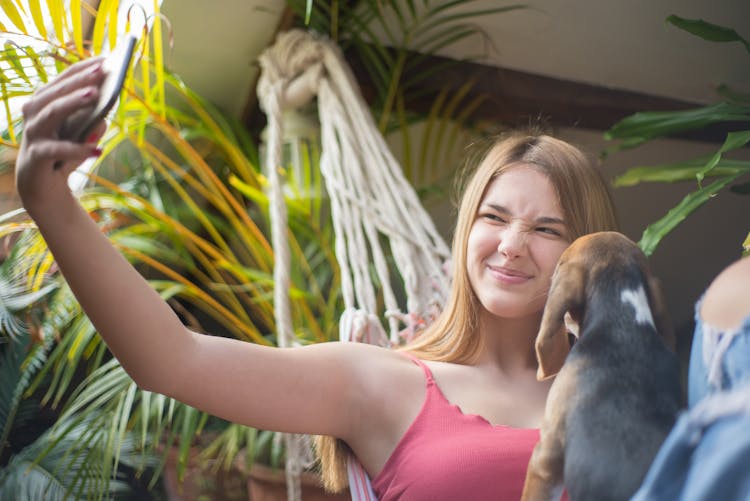 A Woman Taking Selfie With Her Beagle Dog Using A Smartphone