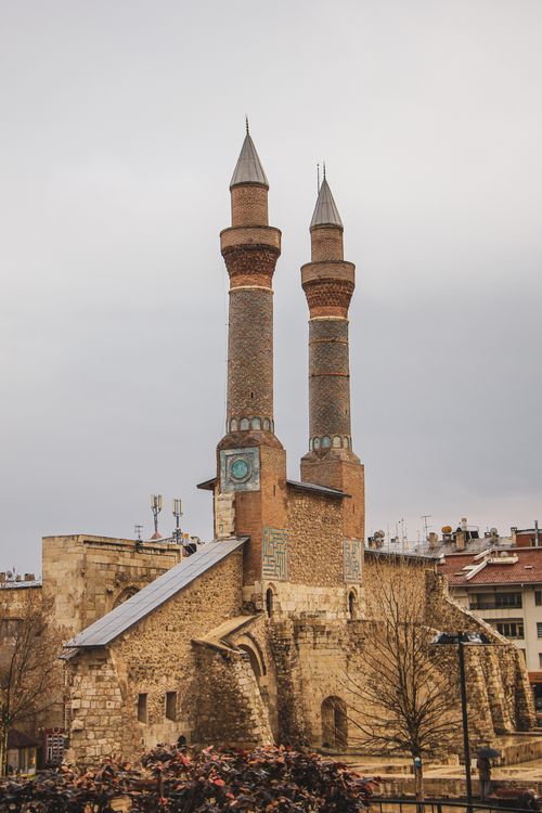Free View of the historic Cifte Minareli Medrese with its iconic twin minarets under a gray sky in Erzurum, Turkey. Stock Photo