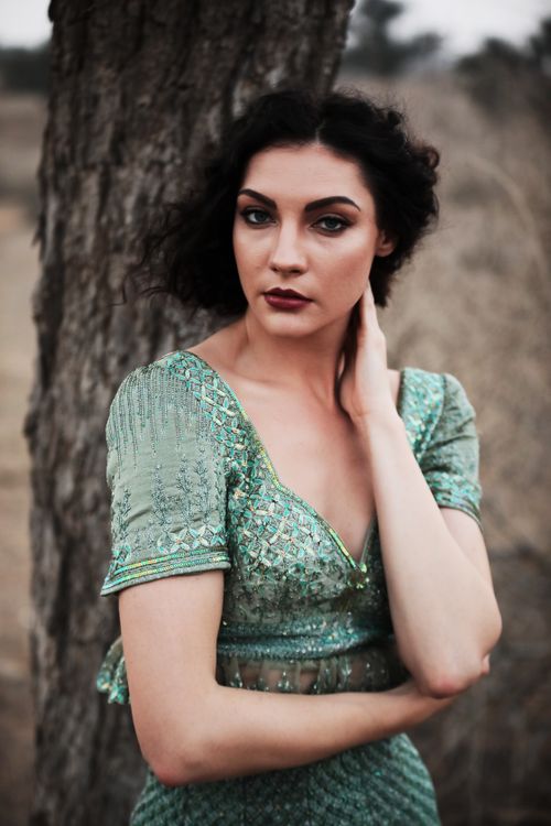 Free Portrait of a woman in a green dress posing outdoors in Rajsamand, India. Stock Photo