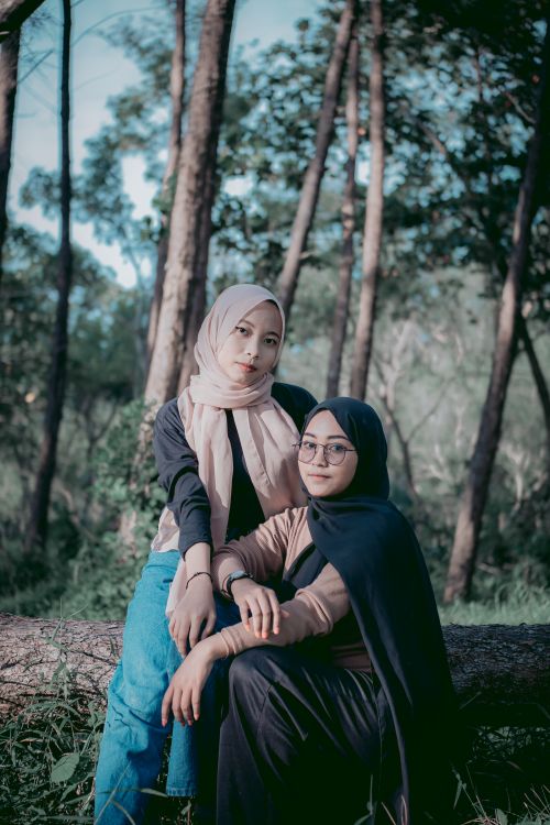 Free Two women in hijabs posing gracefully in a lush forest setting. Stock Photo