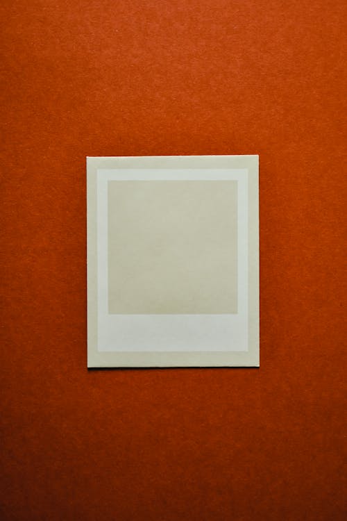 A Polaroid Instant Film on Orange Surface