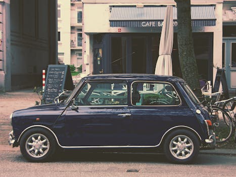 A vintage Mini Cooper parked in front of Café Barco, capturing classic city life charm.