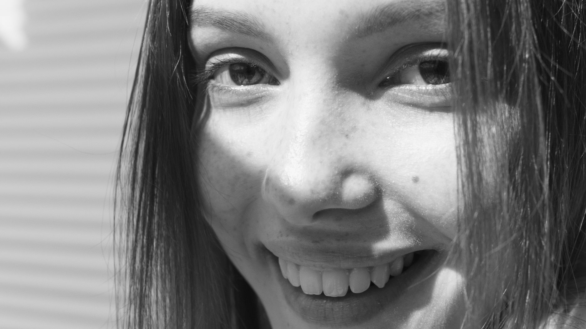 Göz çevresindeki kasların hareketlerini ve sahte gülümsemenin anatomisini gösteren yakın plan insan yüzü fotoğrafı.