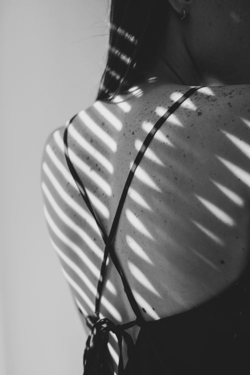 Free Monochrome image showcasing dynamic shadows on a woman's back with freckles. Stock Photo
