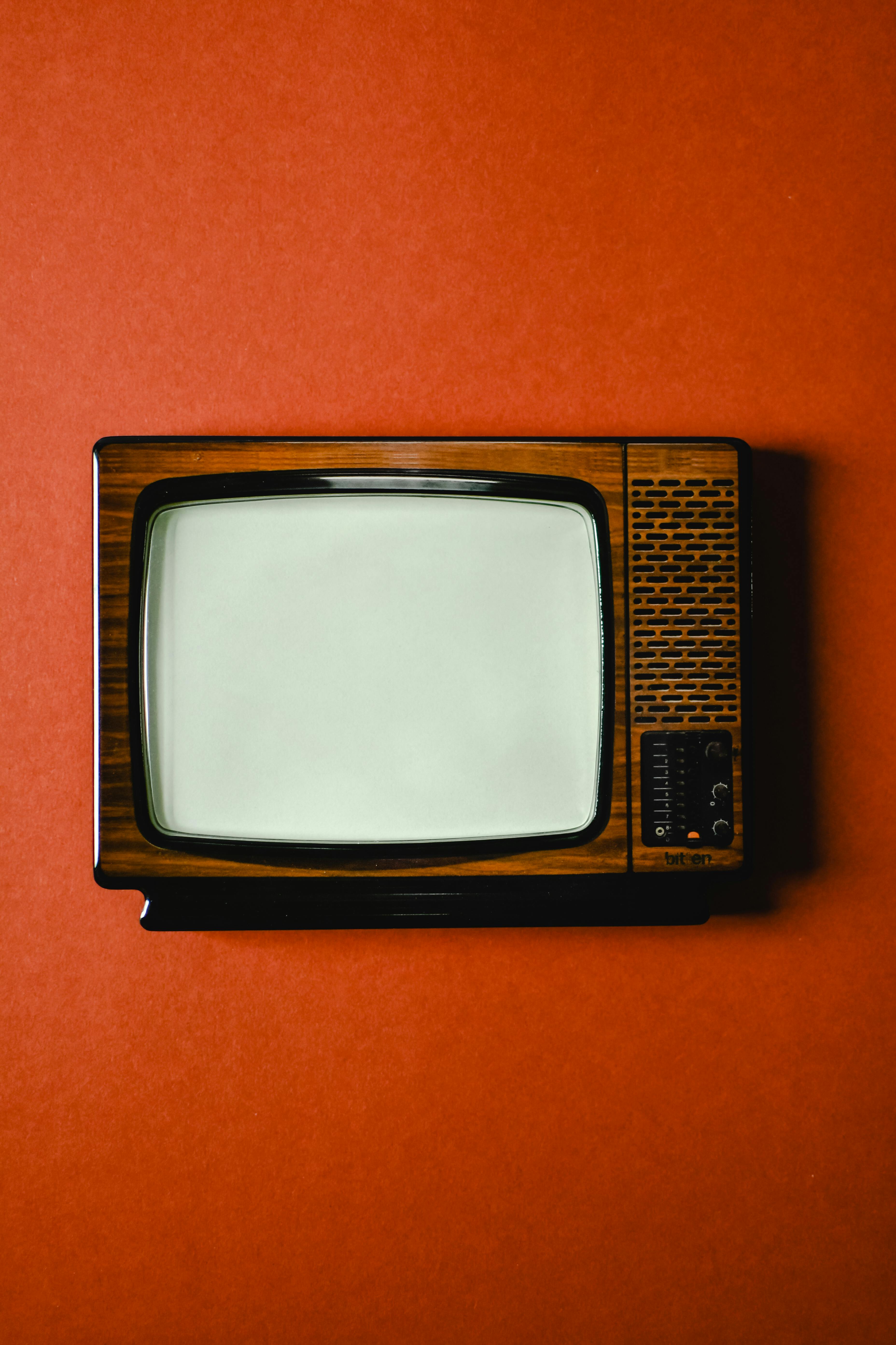an antique television set on orange surface