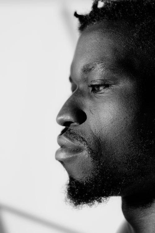 Free A contemplative black and white portrait of a man's side profile with strong shadows. Stock Photo