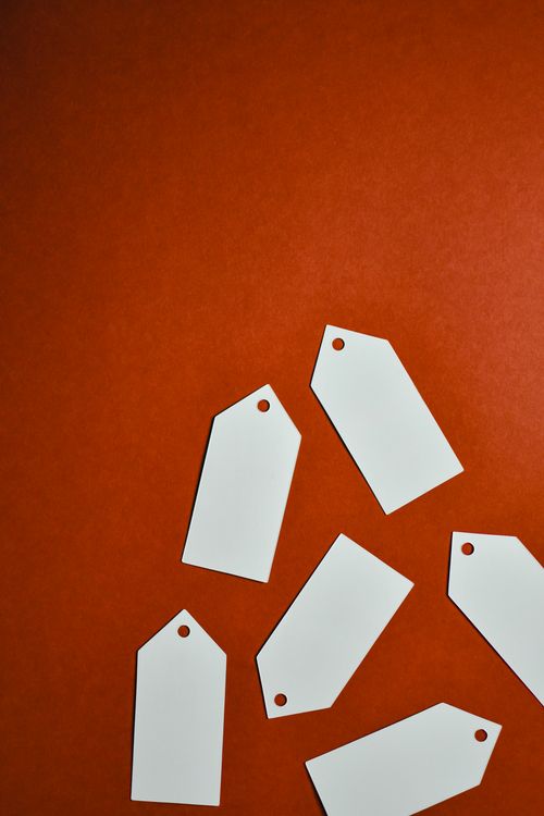 Free Stylish arrangement of blank white tags on a vibrant red surface, ideal for business use. Stock Photo