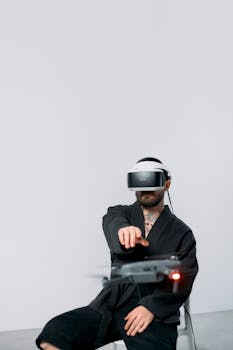 A man using a VR headset to control a drone in a studio setting with a plain background.