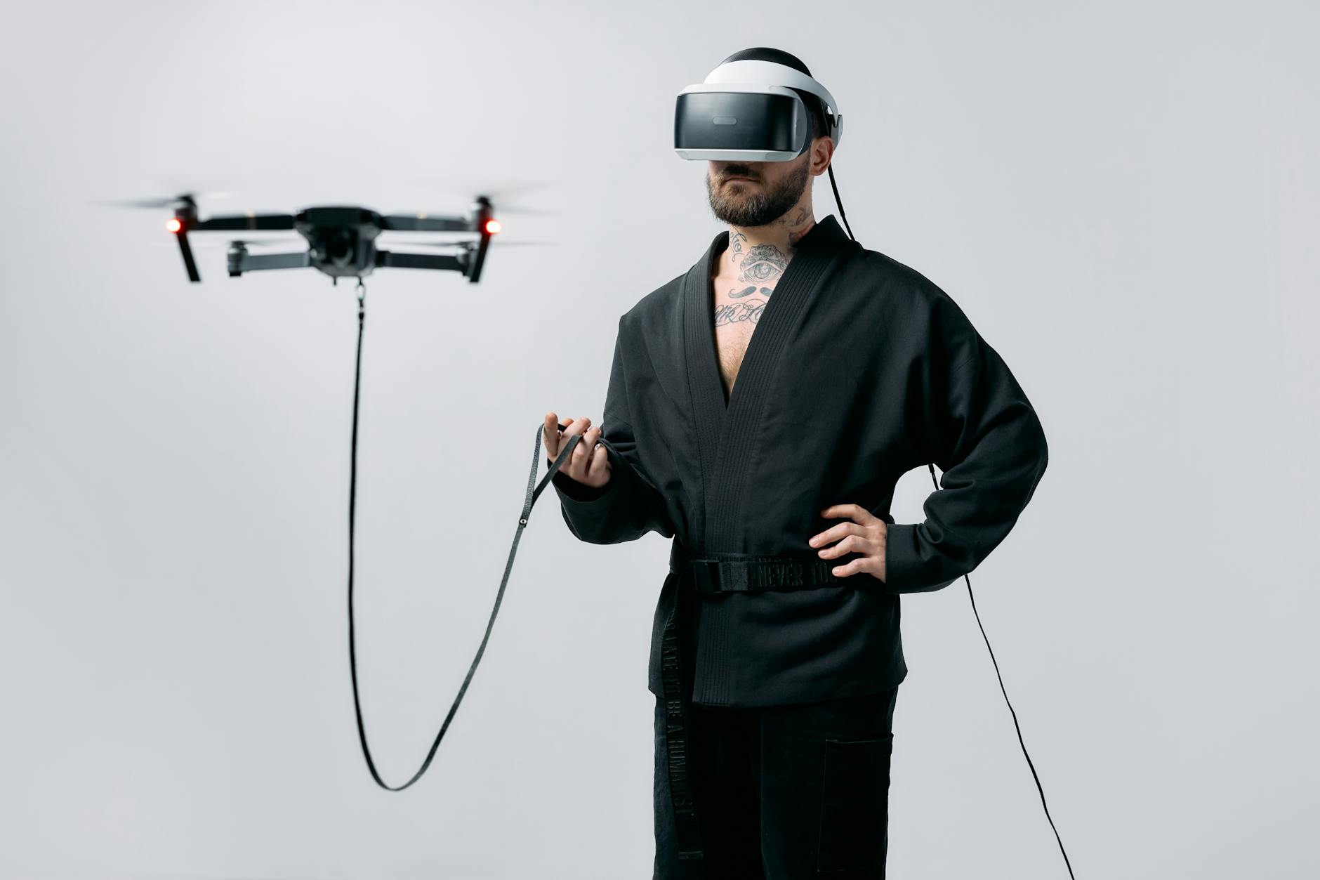 A man uses a VR headset to control a drone in a studio setting, highlighting innovation.