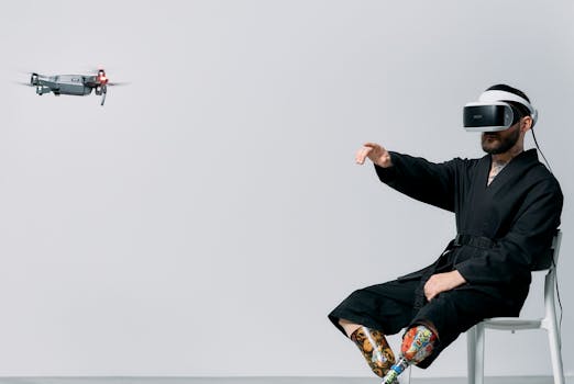 A man with prosthetic legs engages in virtual reality with a drone hovering nearby in a studio setting.