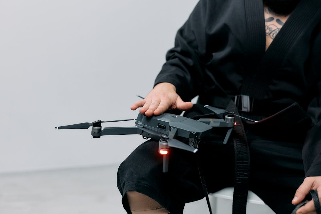 Free Photo of Man Holding Drone on his Lap Stock Photo