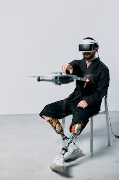 A man with prosthetic legs controlling a drone with VR goggles indoors.
