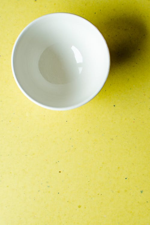 White Ceramic Bowl on Yellow Table