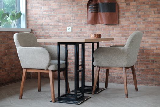 Stylish contemporary indoor seating arrangement showcasing modern furniture and a brick wall backdrop. - Fotografer Sidoarjo