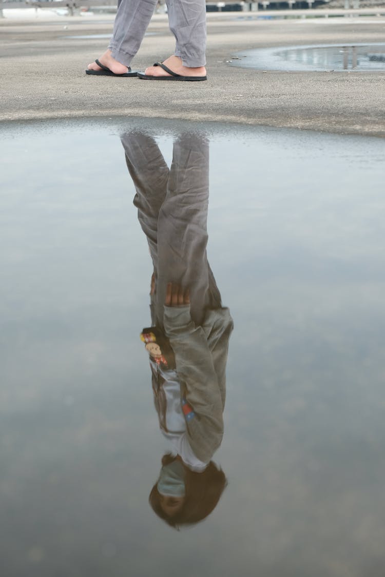 Photo Of A Puddle With A Reflection Of A Woman Standing