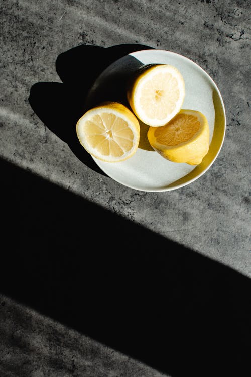 Close-Up Photo of Halved Lemons on a Plate