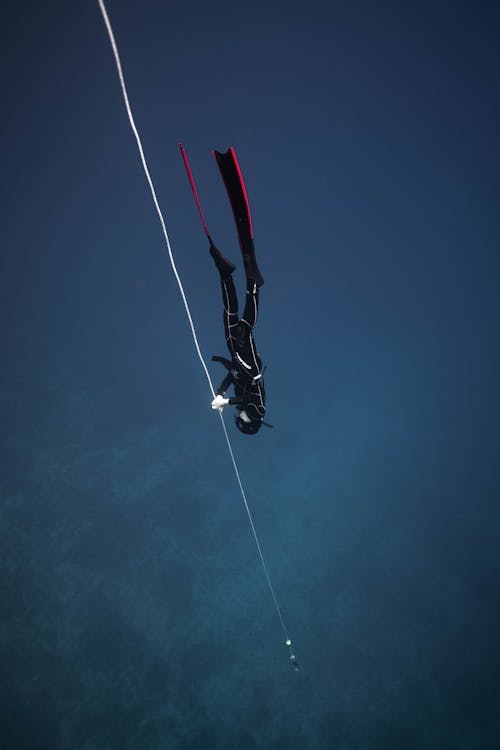 Unrecognizable diver in deep sea water