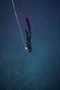 Unrecognizable diver in deep sea water