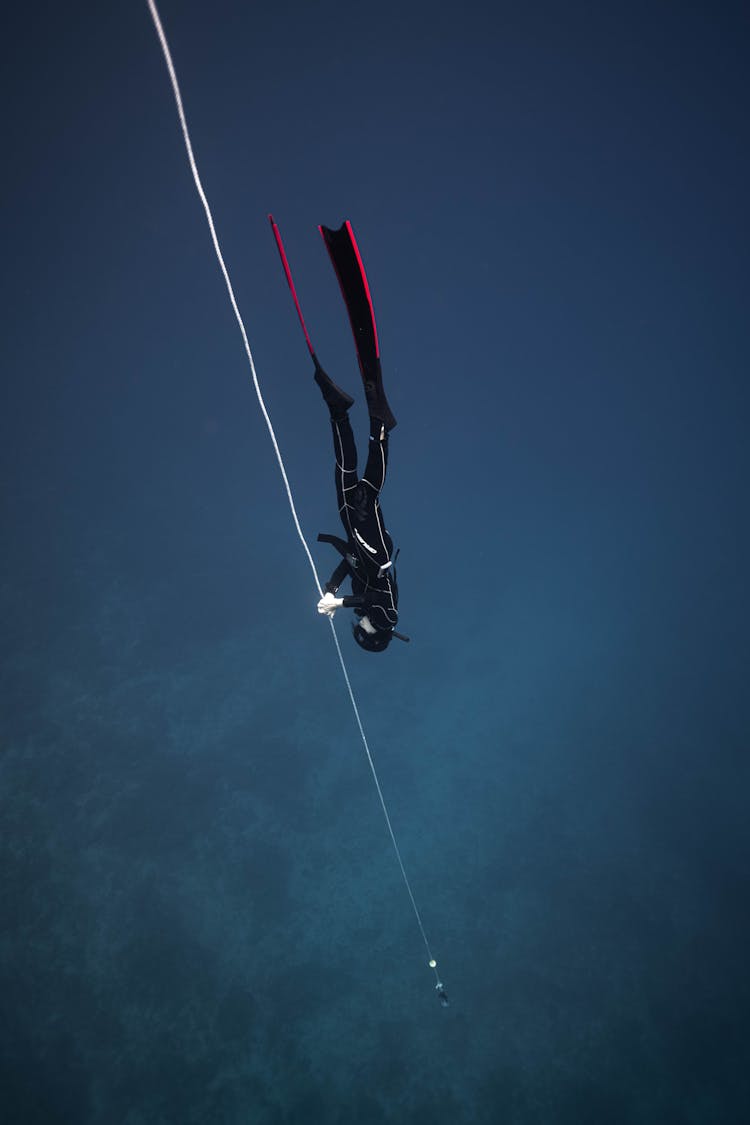 Unrecognizable Diver In Deep Sea Water