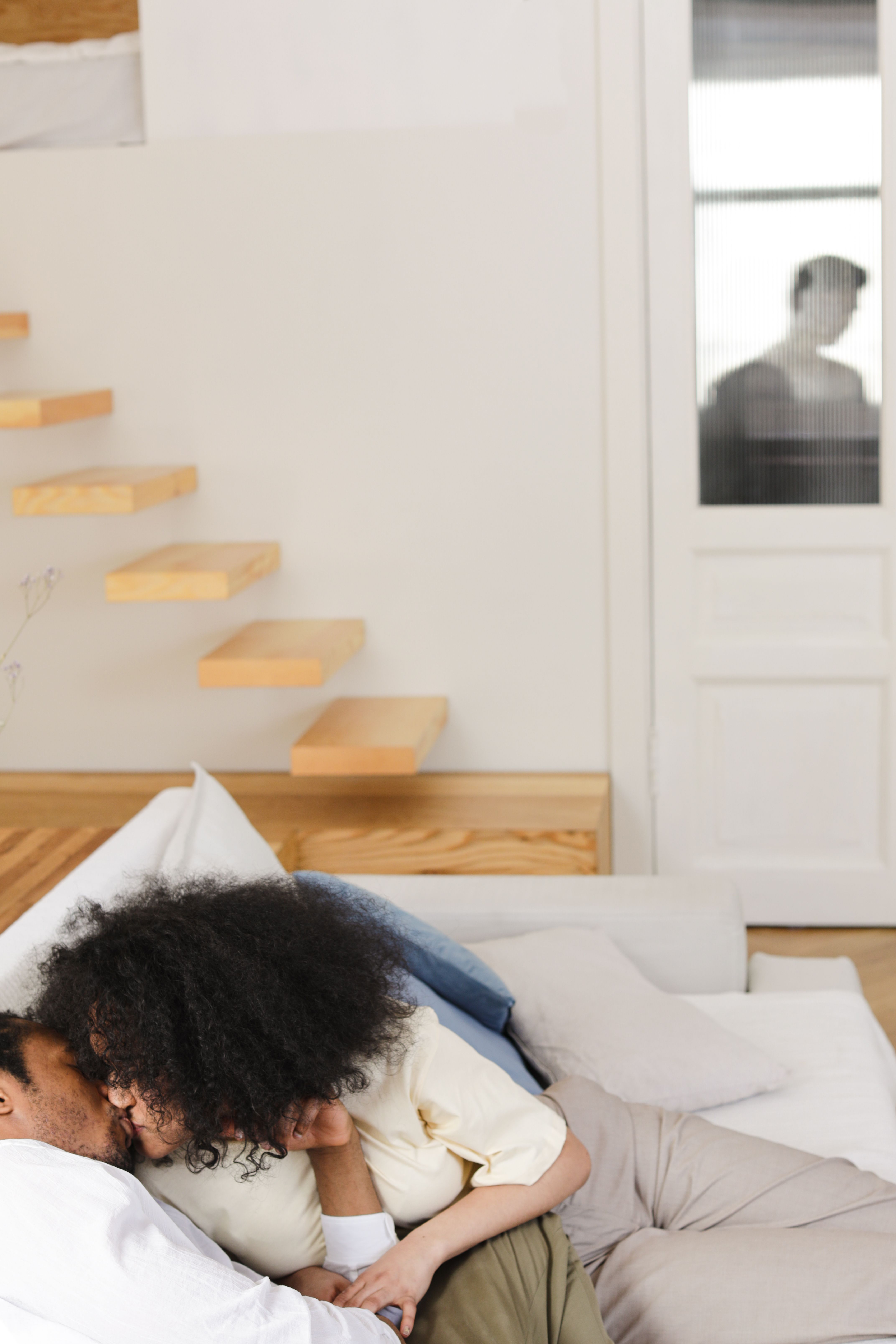 Intimate moment of a couple relaxing on a sofa with stylish wooden decor.