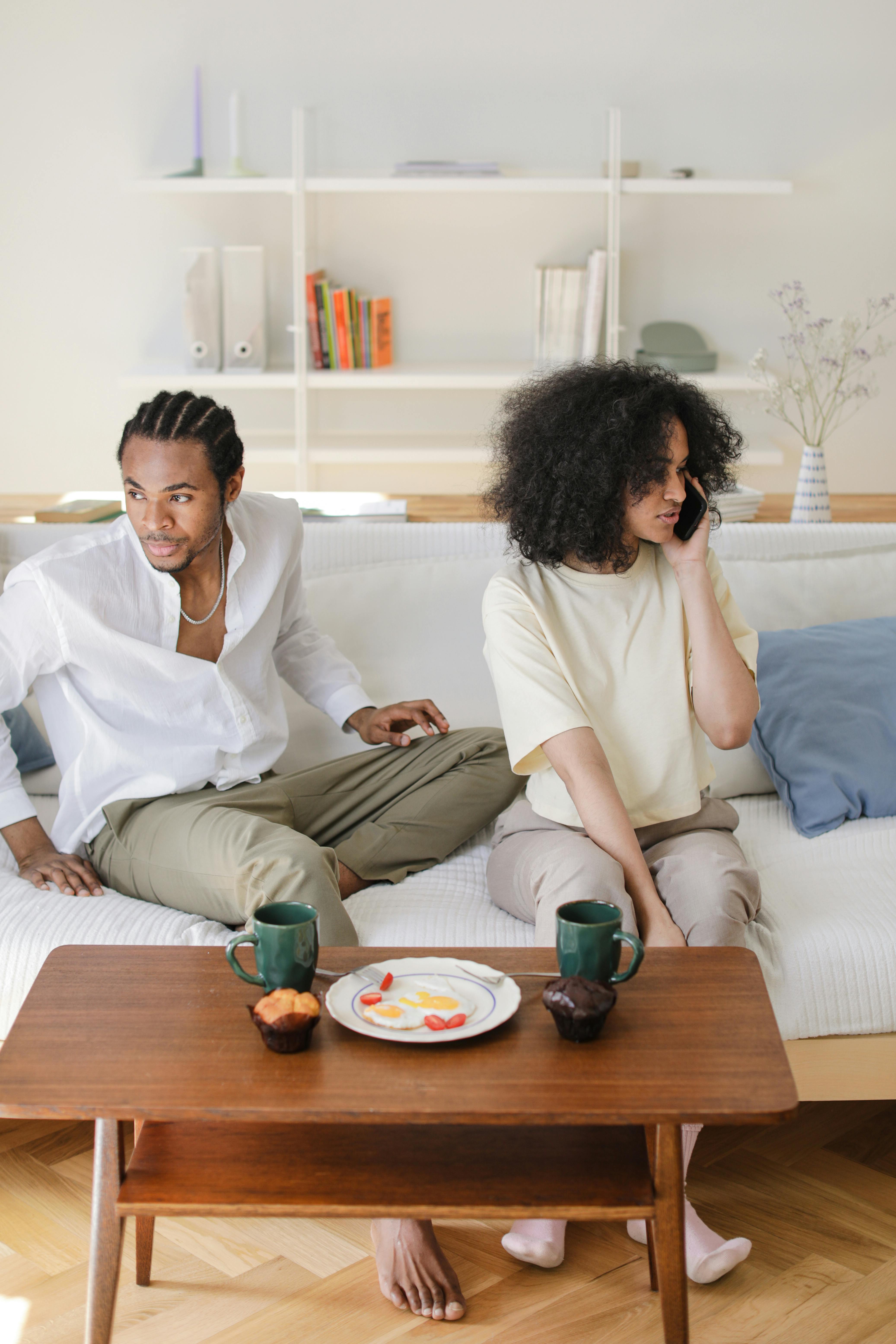 African American couple relaxing at home, enjoying coffee and conversation.