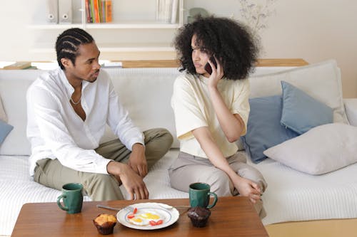Free A Man and Woman Sitting on Couch Looking at Each other Stock Photo