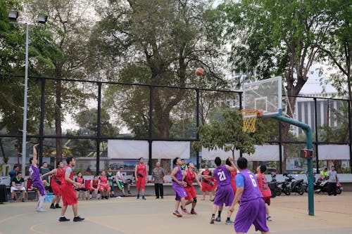 Uniformed People Playing Basketball 