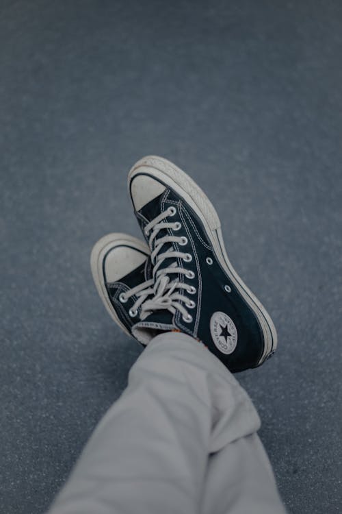 Free Close-Up Photo of a Person Wearing Black and White Converse Shoes Stock Photo