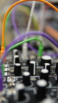 Vibrant close-up view of an audio mixing panel with colorful wires and knobs.