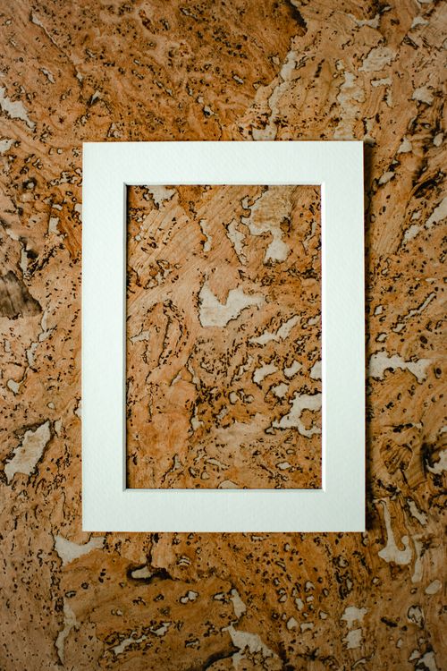 Free Elegant white frame placed on a textured marble surface. Ideal for mockups and design showcases. Stock Photo